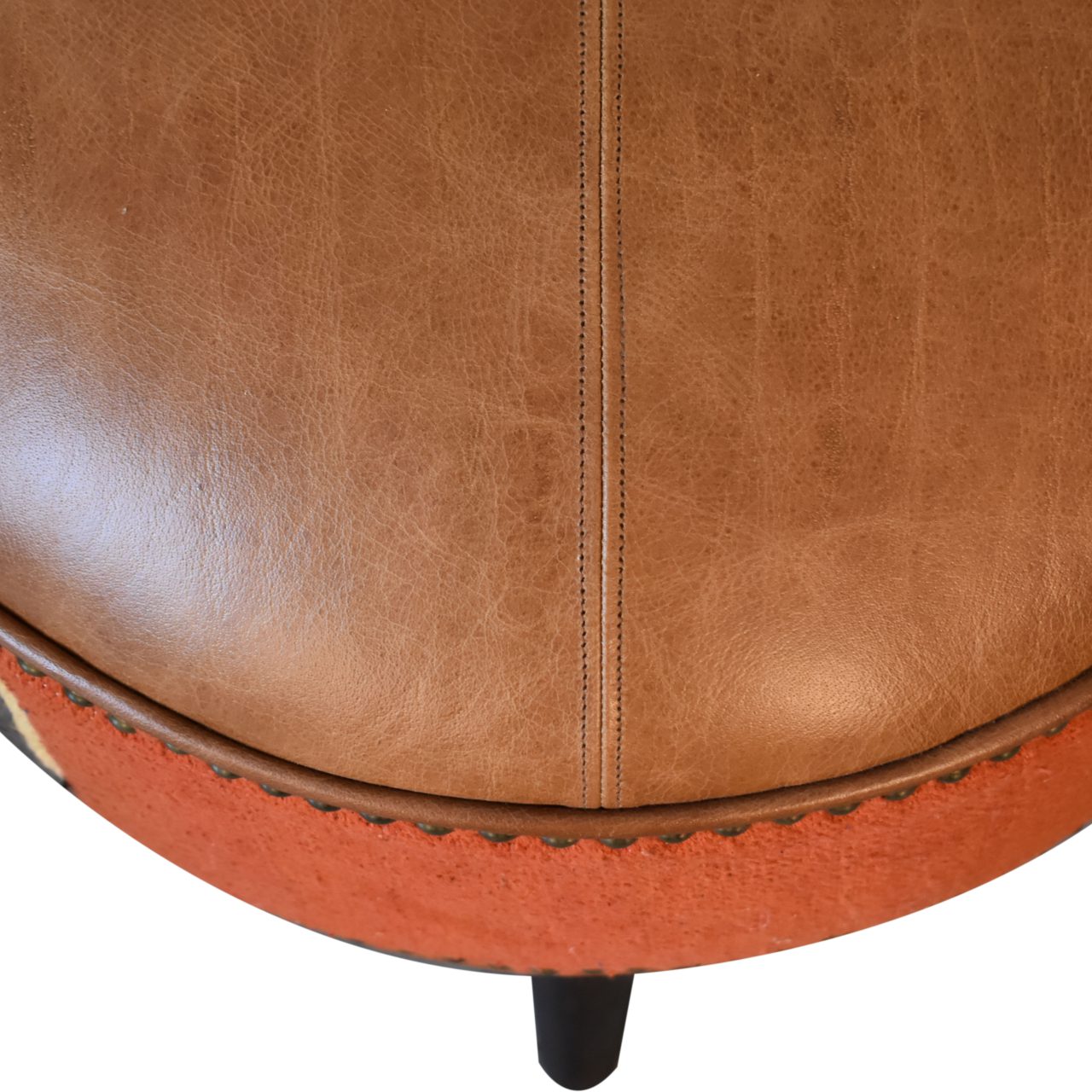 Durrie & Leather Mixed Footstool with Nordic-style legs, buffalo leather, and durrie print. Top view of leather