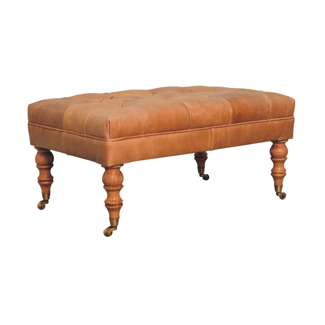Tan buffalo leather ottoman with solid mango wood base, deep-buttoned top, and light walnut hand-turned feet. Corner view