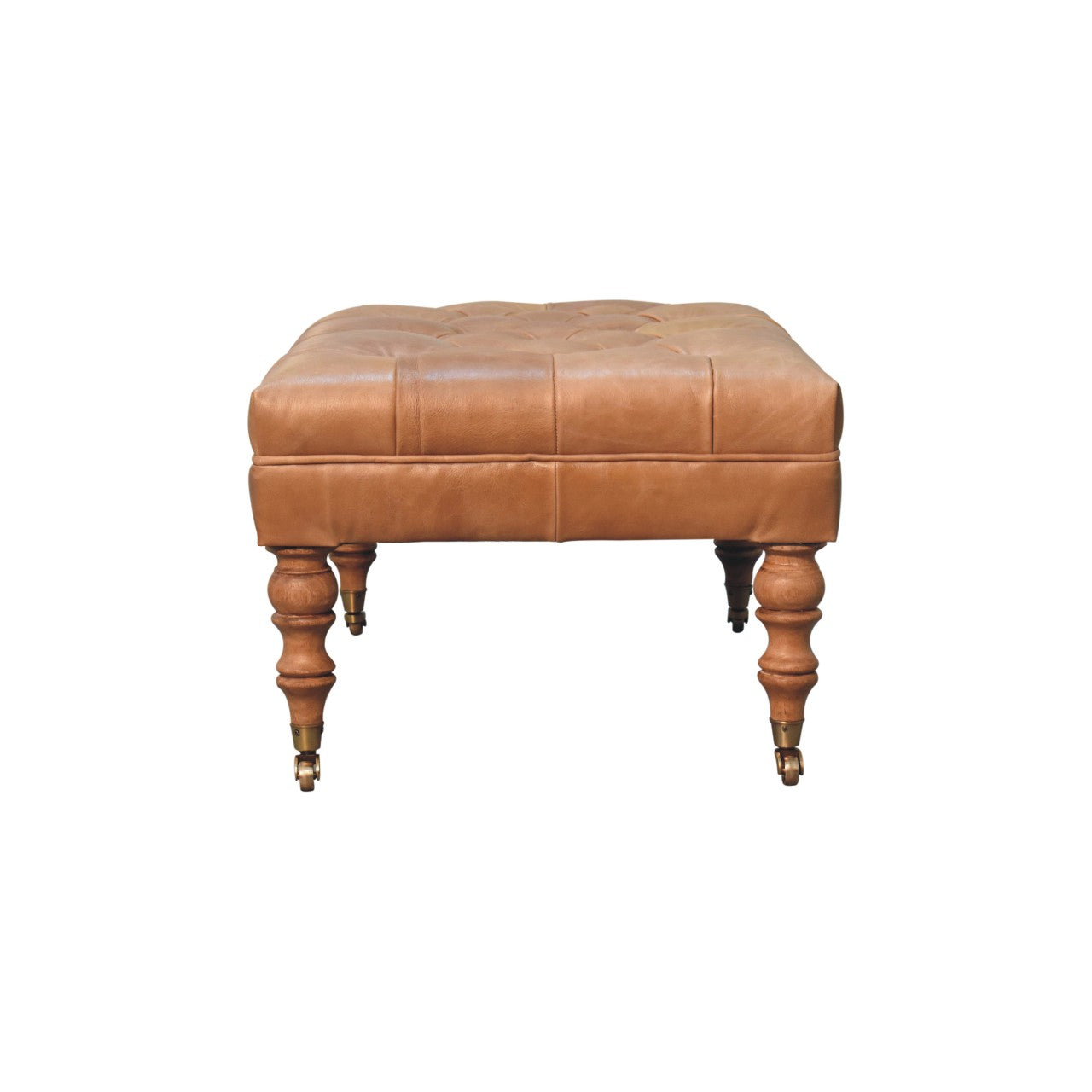 Tan buffalo leather ottoman with solid mango wood base, deep-buttoned top, and light walnut hand-turned feet. Side view